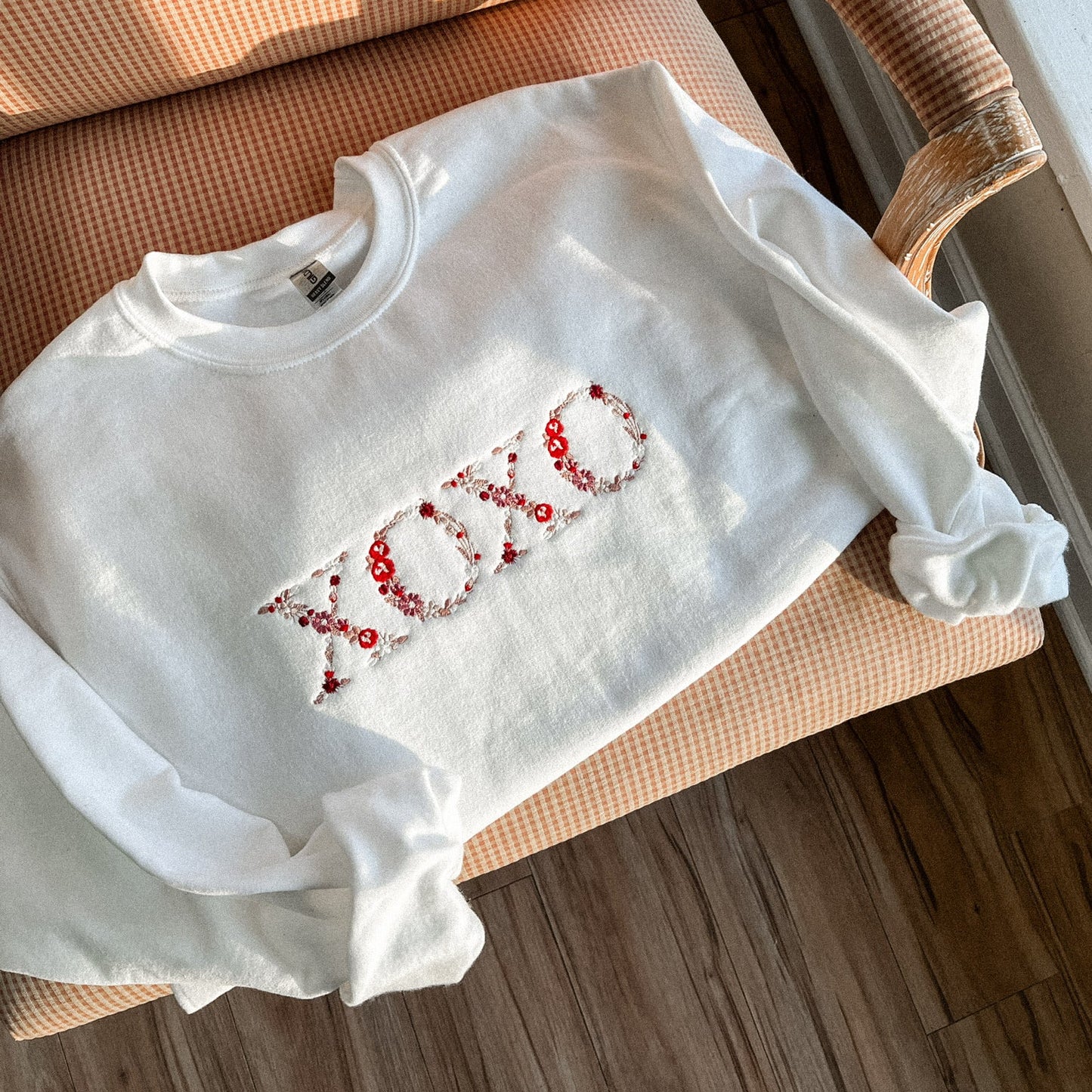 White sweatshirt with red text on a chair